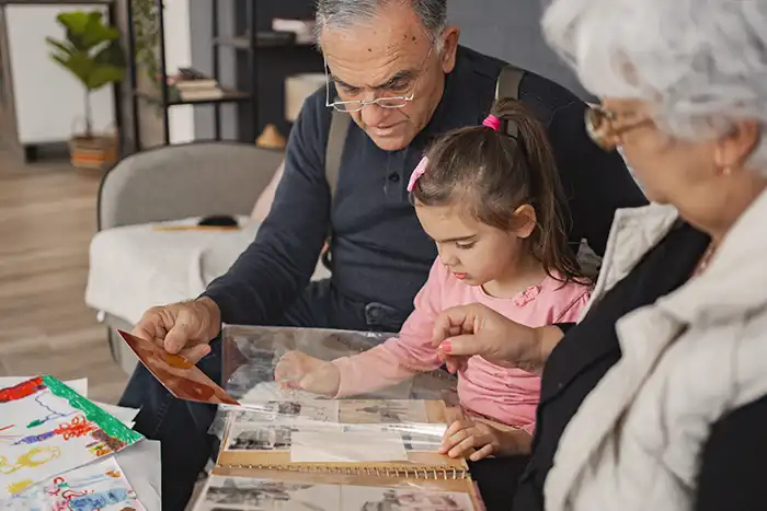 grandparents and granddaughter looking at photos