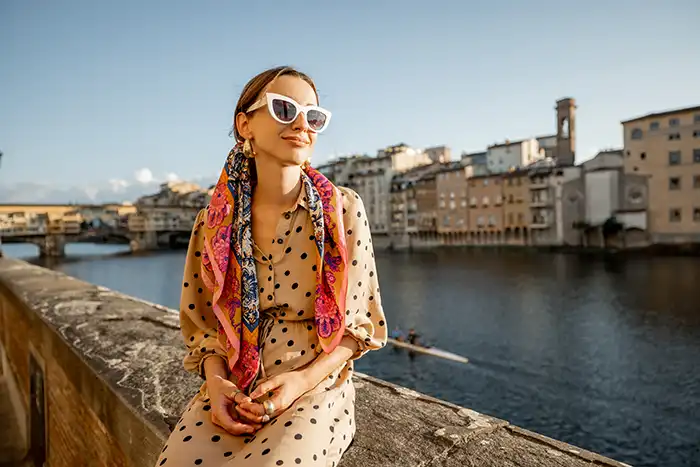 Girl sitting near Ponte Vecchio with white vintage sunglasses