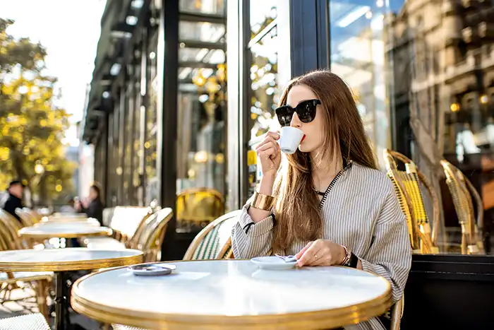 girl takes espresso in historic café