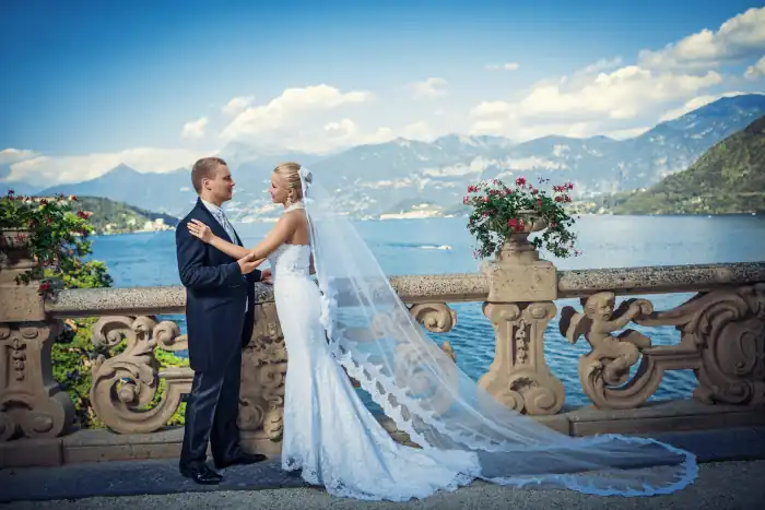 newlyweds on a balcony with view of lake como