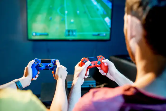 couple playing football game with gaming console